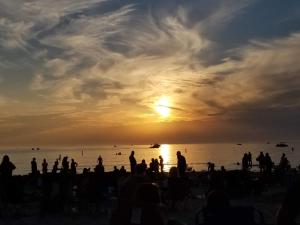 una multitud de personas en la playa al atardecer en Cozy cottage just minutes from Lake Michigan! en Pentwater