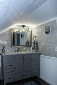 a bathroom with a sink and a mirror at Cozy cottage just minutes from Lake Michigan! in Pentwater