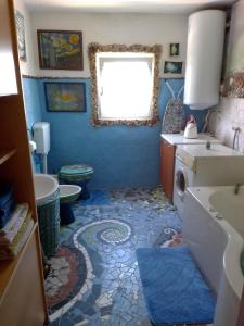 a blue bathroom with a sink and a toilet at Apartman SIRENA in Pićan
