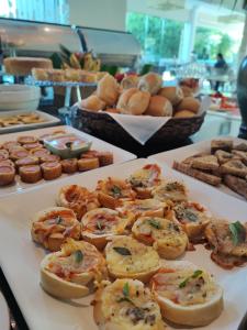a buffet of food with shrimp and other pastries and bread at Hotel Coral Beach in Tamandar&eacute;