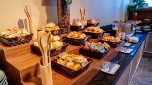um buffet com várias cestas de pão e pastelaria em HY Apartments & Hotels no Recife