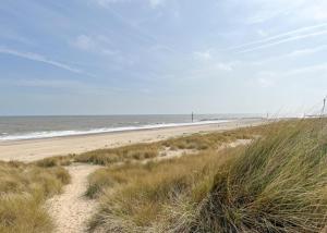 a sandy beach with a view of the ocean at Anchor Park in Happisburgh