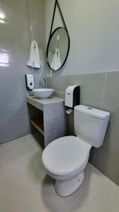 uma casa de banho com um WC branco e um lavatório. em Innbox - Porto Belo em Porto Belo