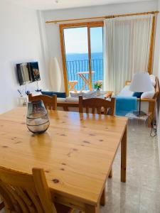 salon ze stołem i widokiem na ocean w obiekcie Apartamentos Sa Tenassa w miejscowości Colonia Sant Jordi