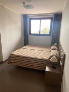 a small bedroom with a bed and a window at Aparthotel El Faro in Cullera