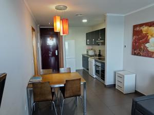 a kitchen and dining room with a table and chairs at Aparthotel El Faro in Cullera