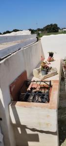 una barbacoa junto a una pared de hormigón en I trulli di Mani', en Masseria Orimini
