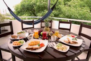 a wooden table with plates of food on it at Poblado Guest House in Medellín