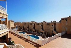 a building with two swimming pools in a courtyard at Residencial Benimar Licencia Vv in Adeje