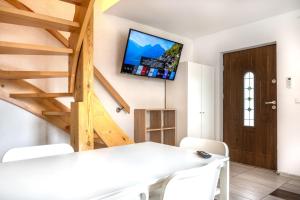 a living room with a table and a tv on the wall at Domki Letniskowe in Grzybowo