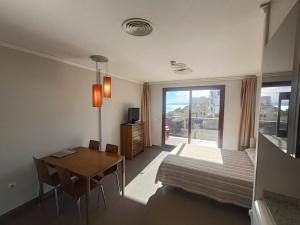 a bedroom with a bed and a desk and a table at Aparthotel El Faro in Cullera