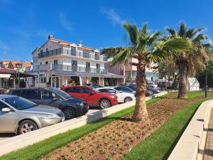 un grupo de coches estacionados en un estacionamiento con palmeras en Apartments Centar, en Vodice