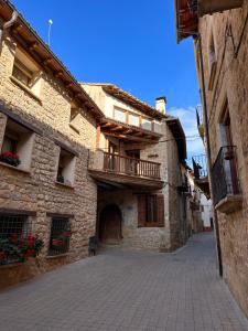 een steegje in een oud stenen gebouw met een balkon bij La Caseta in Arnés