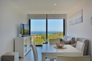 a dining room with a table and chairs with a view of the ocean at Sukha Apartments by NRAS in Gran Alacant