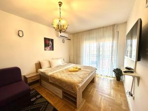 sypialnia z łóżkiem z wypchanym zwierzakiem w obiekcie YellowHouse w Prisztinie