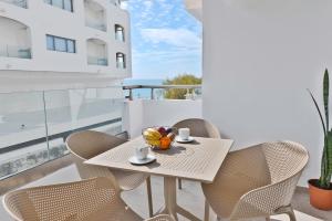 a table with chairs and a bowl of fruit on a balcony at El mare in Ierapetra