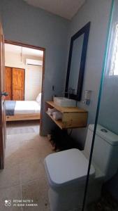 een badkamer met een toilet, een wastafel en een bed bij Danshari Aparta-Estudio Próximo al Malecón in Santa Cruz de Barahona