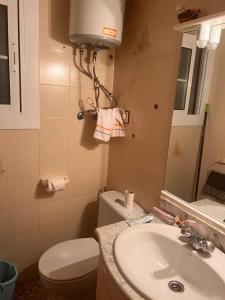 a small bathroom with a toilet and a sink at Playa home in Cunit