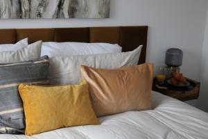 1 cama con sábanas blancas y almohadas amarillas en Charming 2 Bed House - Family Friendly en Nottingham