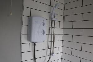 y baño con ducha y pared de azulejos blancos. en Charming 2 Bed House - Family Friendly en Nottingham