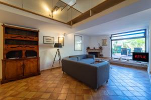 ein Wohnzimmer mit einem Sofa und einem TV in der Unterkunft Claudia's home 2 in Alghero