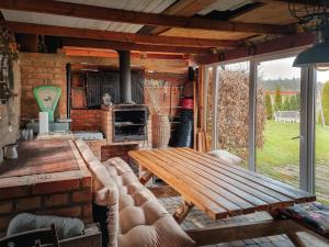 a living room with a wooden table and a fireplace at Domki Letniskowe in Grzybowo