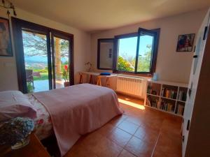 a bedroom with a bed and two large windows at Espectacular casa a dos minutos de Playa America in Nigrán
