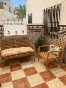 two benches sitting on top of a tile floor at Hostal Avenida by Bossh! Hotels in Chipiona