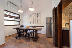 eine Küche mit einem Tisch und einem Kühlschrank in der Unterkunft Claudia's home 2 in Alghero