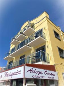 a yellow building with a store sign in front of it at Hotel Oceano in Nazaré