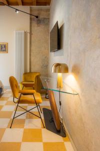 un soggiorno con tavolo in vetro e sedia di Palazzo Scappi Gardi Luxury Apartments a Bologna