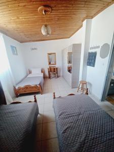 una camera con 2 letti e un soffitto in legno di Olive holiday home a Laganas