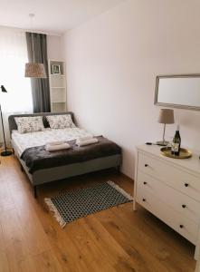 sypialnia z łóżkiem i komodą z lustrem w obiekcie APARTAMENT OGRODY w mieście Leszno