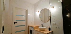 レシュノにあるAPARTAMENT OGRODYの洗面台と洗濯機を備えたバスルーム +9枚の写真