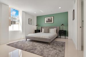 een slaapkamer met een bed en een groene muur bij Roami at The Ralston in Miami