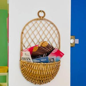 um cesto de livros está pendurado numa parede em Barbapappart - Un studio coloré dans le centre de Rouen em Rouen