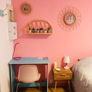 um quarto com uma secretária e uma parede rosa em Barbapappart - Un studio coloré dans le centre de Rouen em Rouen
