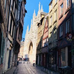 uma rua antiga com uma catedral ao fundo em Barbapappart - Un studio coloré dans le centre de Rouen em Rouen