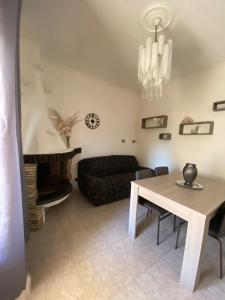 uma sala de estar com uma mesa e um sofá em Casa Iole em Carbonia
