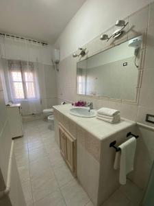 uma casa de banho com um lavatório, um espelho e um WC. em Casa Iole em Carbonia