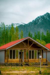 a log cabin with mountains in the background at Greenwood Resort Skardu in Skardu