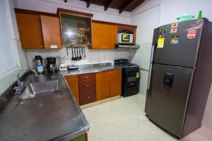 una cucina con frigorifero in acciaio inox e mobili in legno di Spring Hostel a Medellín