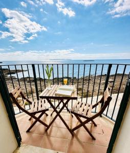 stół i krzesła na balkonie z widokiem na ocean w obiekcie Apartamentos Sa Tenassa w miejscowości Colonia Sant Jordi