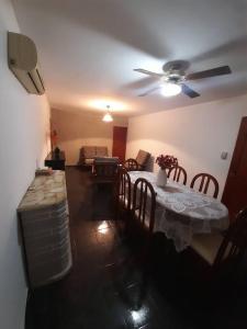 a living room with a table and a ceiling fan at Casa amplia y cómoda in General Alvear +4 photos