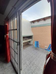 an open door to a patio with two chairs at Casa amplia y cómoda in General Alvear