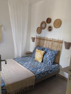 1 dormitorio con 1 cama con almohadas azules y amarillas en Résidence Bois Flotté en Sainte-Anne