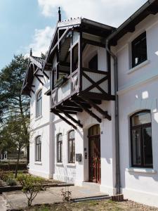 a white house with a balcony on it at HORAMI Villa - NAMDO Apartment mit Terrasse in Malchow