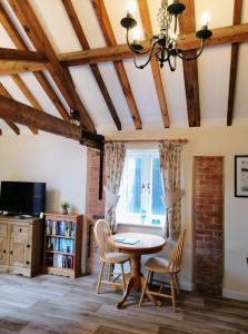 a dining room with a table and chairs and a window at Poplar Cottage in Woodhall Spa