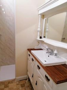 uma casa de banho com um lavatório e um espelho em Poplar Cottage em Woodhall Spa