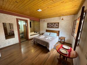 a bedroom with a bed and a bath tub at Pousada Requinte da Serra in Monte Verde